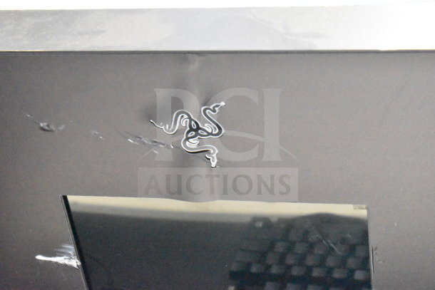 Store display featuring Razer logo, showing partial view of a keyboard. Includes headphones and router. Good condition.