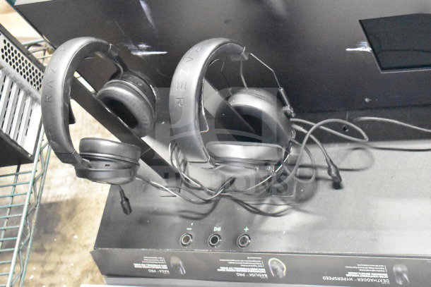 2 Razer headphones on store display with audio controls, part of auction bundle including keyboard and router.