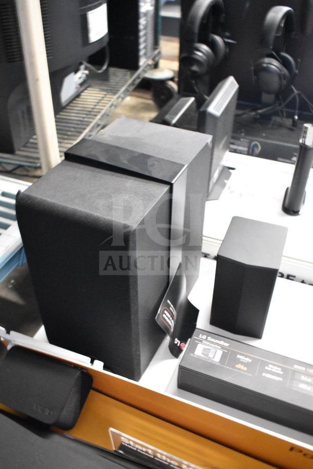 Vizio and LG soundbar with speakers on store display; includes original packaging and labels, showcasing condition and features.