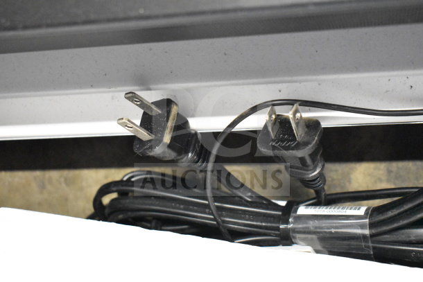 Vizio/LG soundbar cables and plugs on store display. Visible power connectors and partially wrapped cord with barcode.
