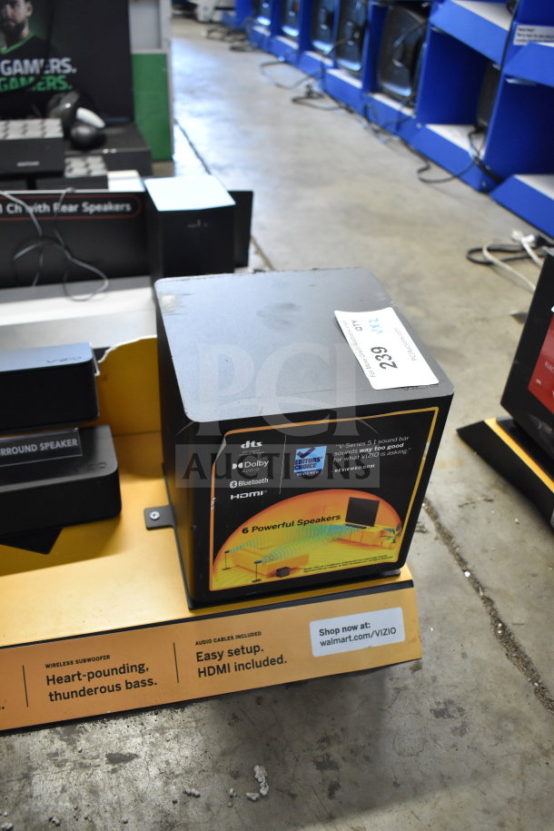 Store display featuring Vizio and LG soundbar and speakers, highlighting Dolby, Bluetooth, and HDMI features. Displays "6 Powerful Speakers" text.