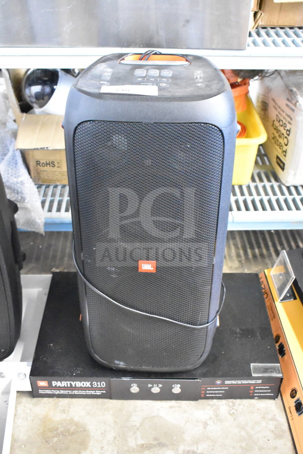 JBL Partybox 310 Speaker on store display, featuring front grille, control buttons, and branding. Good condition.
