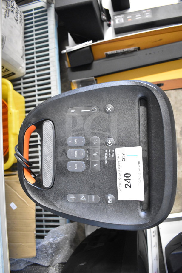 JBL Partybox 310 speaker on store display. Features control panel with buttons for volume, bass, treble, and Bluetooth. Auction tag visible.