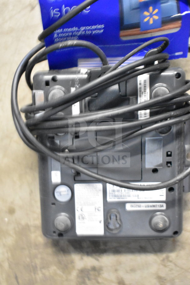 Lot of various corded office telephones, keyboard, and credit card reader. Mixed condition, with visible cords and labels.