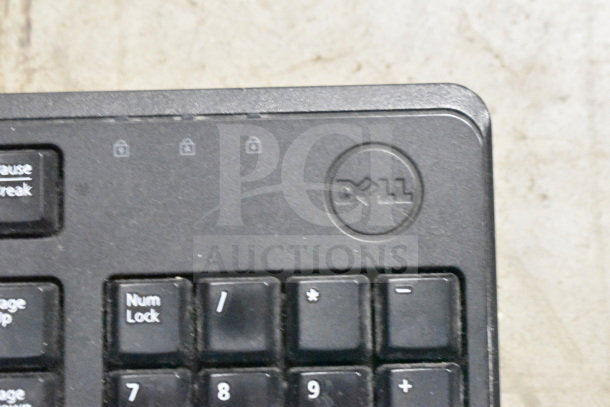 Dell keyboard with visible logo, part of an auction lot including various corded office telephones and a credit card reader.