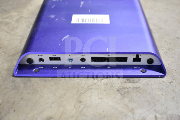 A blue electronic device with ports labeled Audio, USB, IR, Serial, GPIO, and 12V 3A. Visible scuffs and barcode.