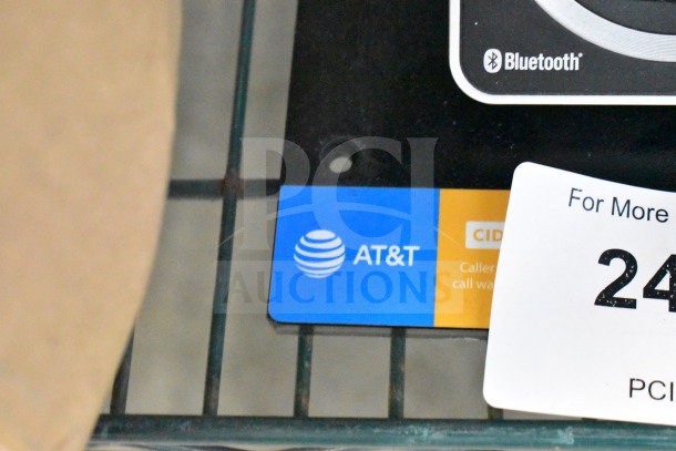 AT&T display with telephones featuring Bluetooth capability. Auction tag indicating two times your bid offer.