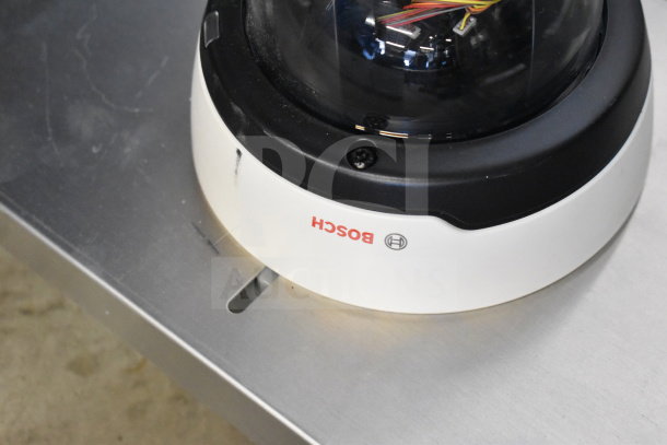 Bosch dome security camera with visible wiring, white base, and logo; used condition.
