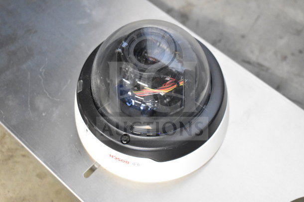 Bosch dome security camera with clear dome and visible wiring inside. Model tag reads "Bosch." Minimal wear.