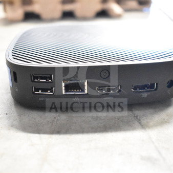 Compact computer dock with multiple ports including USB, Ethernet, HDMI displayed on a concrete surface.