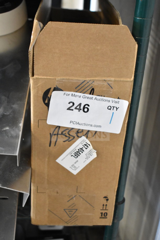 Cardboard box labeled "246" containing a computer mouse, keyboard, and cables for auction. Box shows asset tag.
