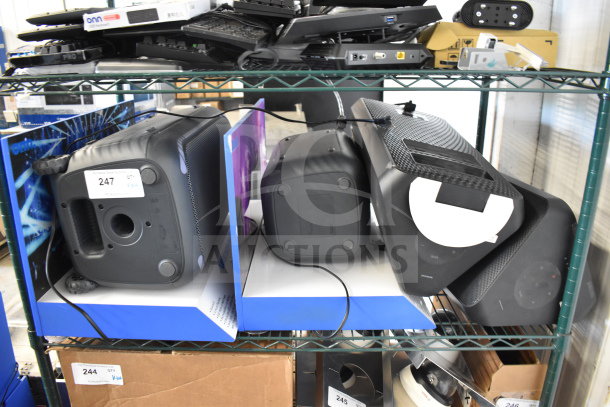 Four items including two store display speakers featuring one Onn and two Samsung speakers on metal shelving. Tags visible.