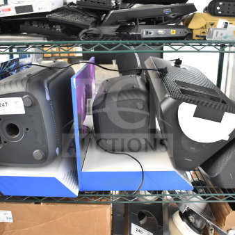 Four items including two store display speakers featuring one Onn and two Samsung speakers on metal shelving. Tags visible.