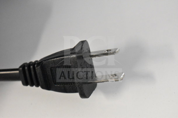 Close-up of a two-prong power plug on a black electric cable, partially shown against a white background.