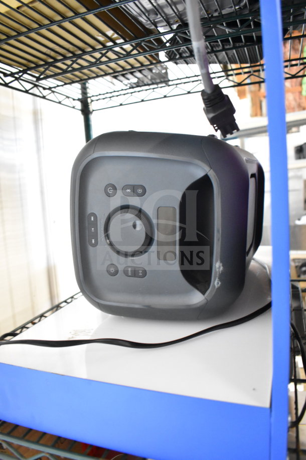 Onn speaker on store display shelf, black finish with control buttons visible; part of a 4-item auction lot.