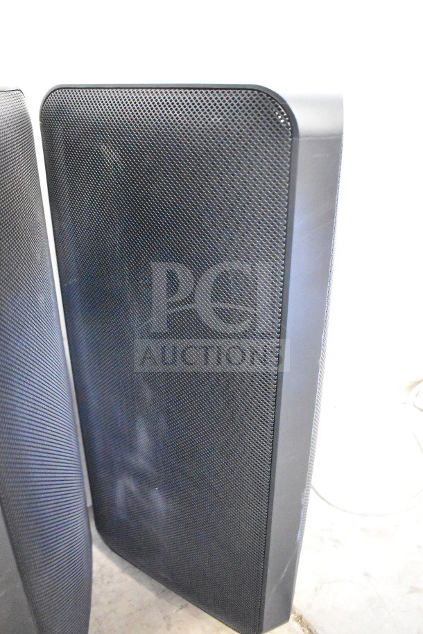 Four black speakers including Onn and Samsung models, store display units, slightly worn, sold as-is.