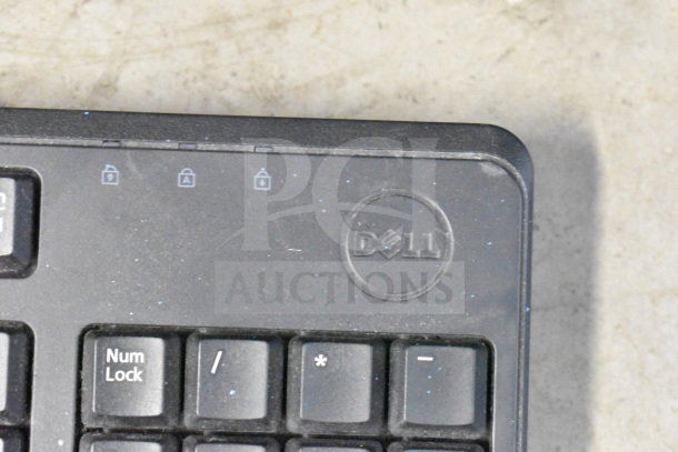 Dell keyboard with visible branding, used condition, part of a lot including keyboards, mice, and Netgear router.