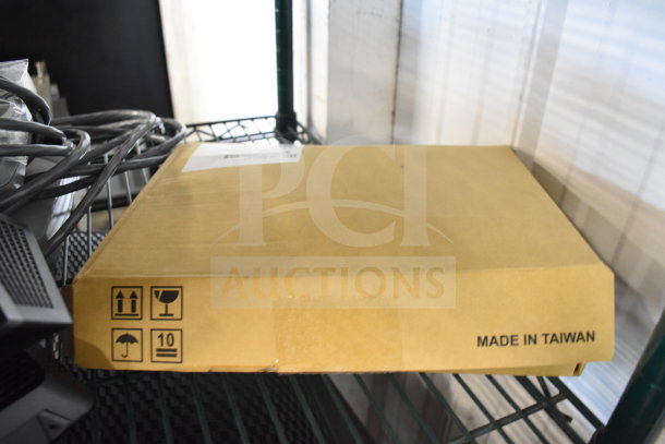 Box of assorted tech items, including keyboards, mice, and a Netgear router. Box marked "Made in Taiwan." Mixed condition.
