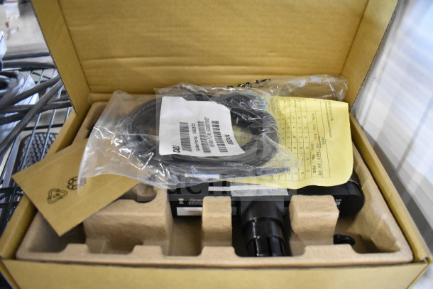 Box with assorted electronics including a Netgear router, cables, and paperwork. Items appear unused, in original packaging.