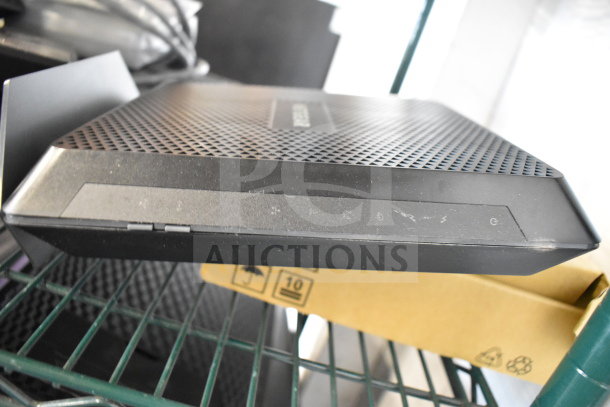 Netgear router with ventilation holes, black finish, light wear. Part of auction lot with keyboards, mice, 20x bid value.