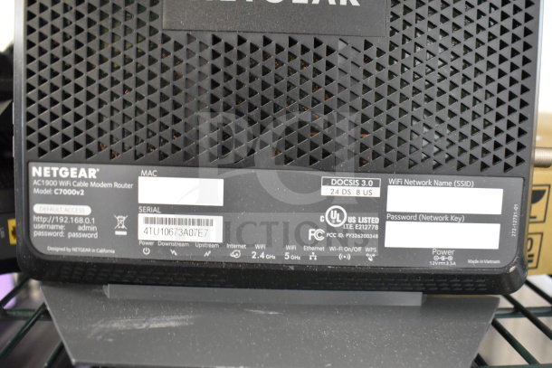 Netgear AC1900 WiFi Cable Modem Router, Model C7000v2, features DOCSIS 3.0, and 2.4GHz/5GHz WiFi bands. Tags show SSID and password details.