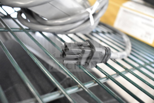 Cables and connectors on a wire shelf. Part of a lot including keyboards, mice, and a Netgear router.