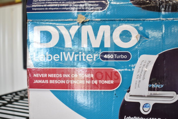 Dymo LabelWriter 450 Turbo box, shows features: "Never Needs Ink or Toner." Worn packaging, visible tear at top.