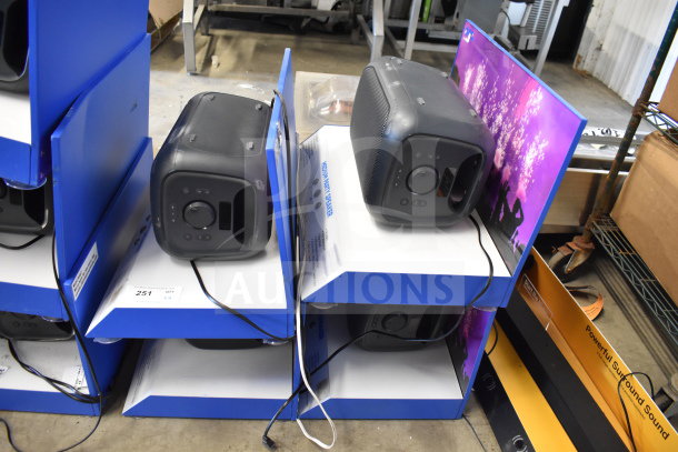 4 Onn medium party speakers on display stands, black, gently used, with power cords and vibrant graphics on the sides.