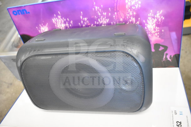 Onn medium party speaker display. Black casing, mesh front, vibrant backdrop. Condition: used, some wear visible.