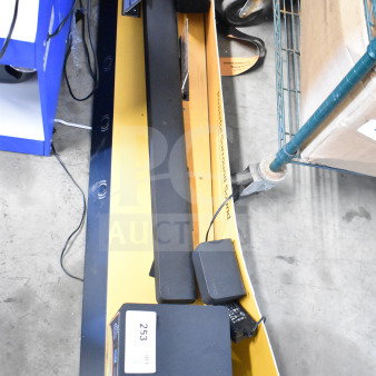 Vizio sound bar and speaker on yellow store display, cords attached. Tags indicate item number 253.