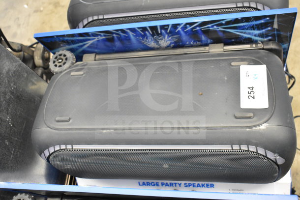 4 Onn Large Party Speakers in store display; black, rectangular design with mesh grill. Label indicates "QTY 4".