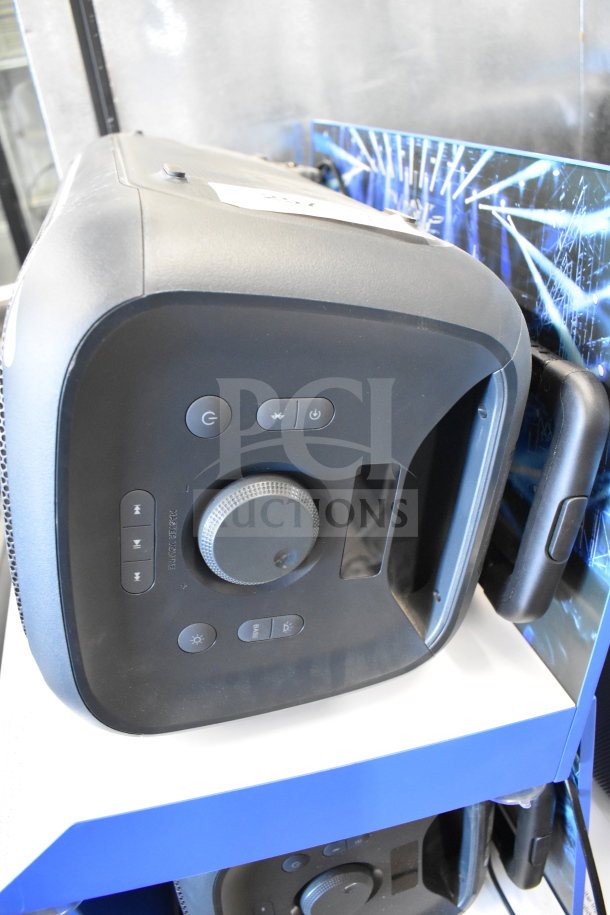 Onn large party speaker on store display with controls and handle visible, showcasing its durability and functionality.