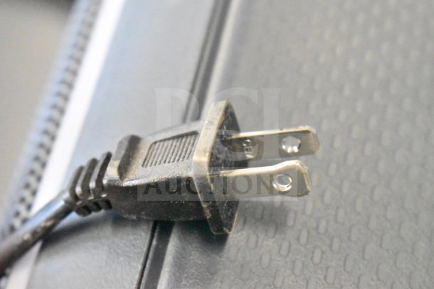 Plug for Onn Large Party Speaker, shown on store display. Close-up of two-prong power connector.