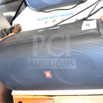 JBL Partybox 110 Bluetooth speaker on store display. Black with orange accents, branded with JBL logo, new condition.