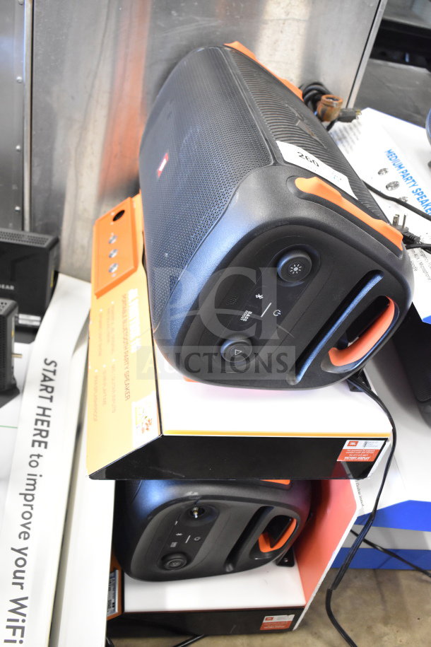 Two JBL Partybox 110 Portable Bluetooth Party Speakers in store display, showcasing sleek design and controls.