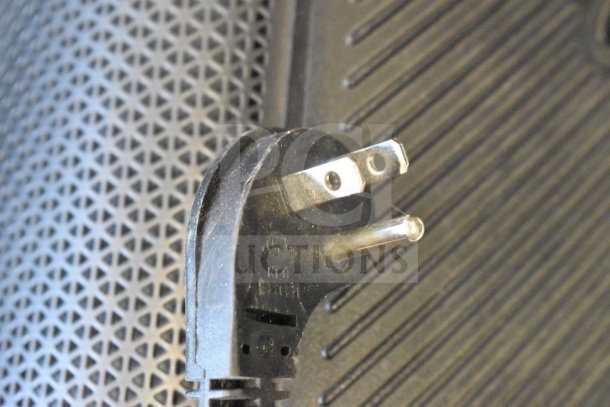 JBL Partybox 110 power plug close-up on a textured speaker surface, showcasing a store display condition.