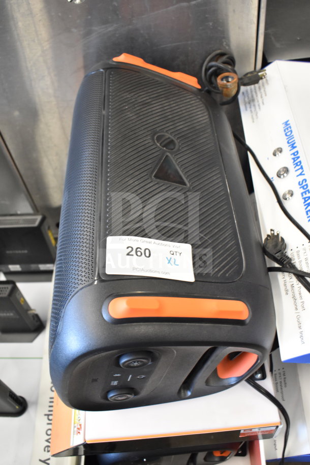 JBL Partybox 110 Portable Bluetooth Speaker, store display, prominent rubber handle, control panel visible, label with auction details attached.