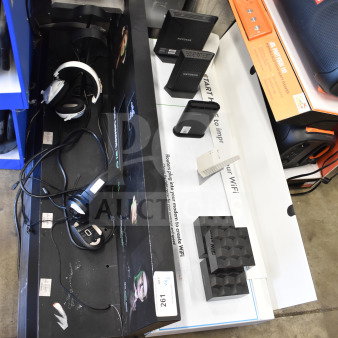 Store display with Netgear routers and headphones in used condition. Includes box labels and product tags.