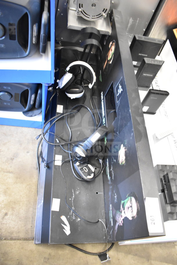 Store display featuring routers and headphones, various brands. Display includes marketing graphics. Item condition is used.