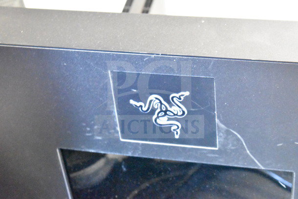 Store display with Razer logo, featuring routers and headphones. Wear visible; includes promotional offer for doubling bids.