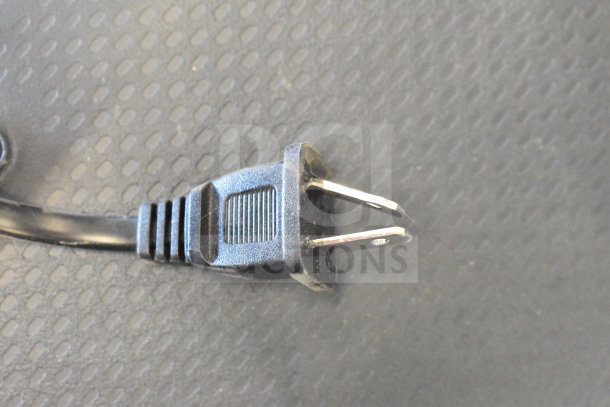 Close-up of a power plug for an Onn Large Party Speaker on a textured surface. The plug appears to be in good condition.