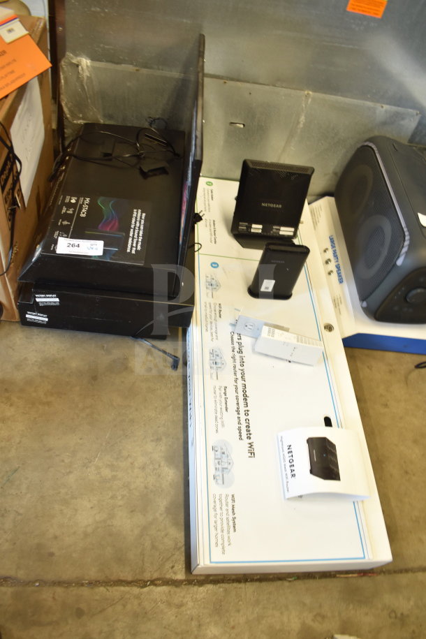 Store display with multiple items including Netgear routers and accessories. Box label indicates networking equipment.