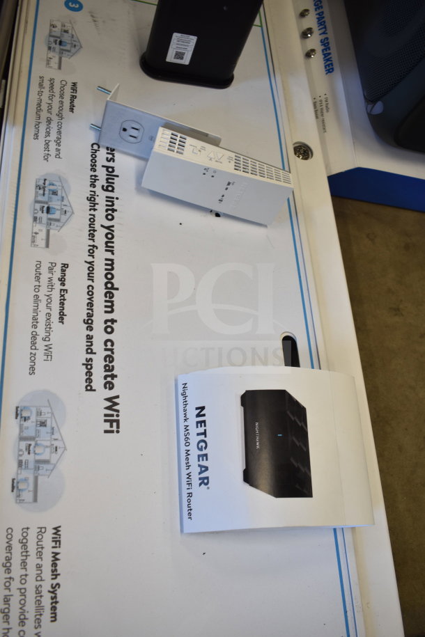 Netgear Nighthawk M560 Mesh WiFi Router on display, includes packaging. Store display with setup instructions visible.