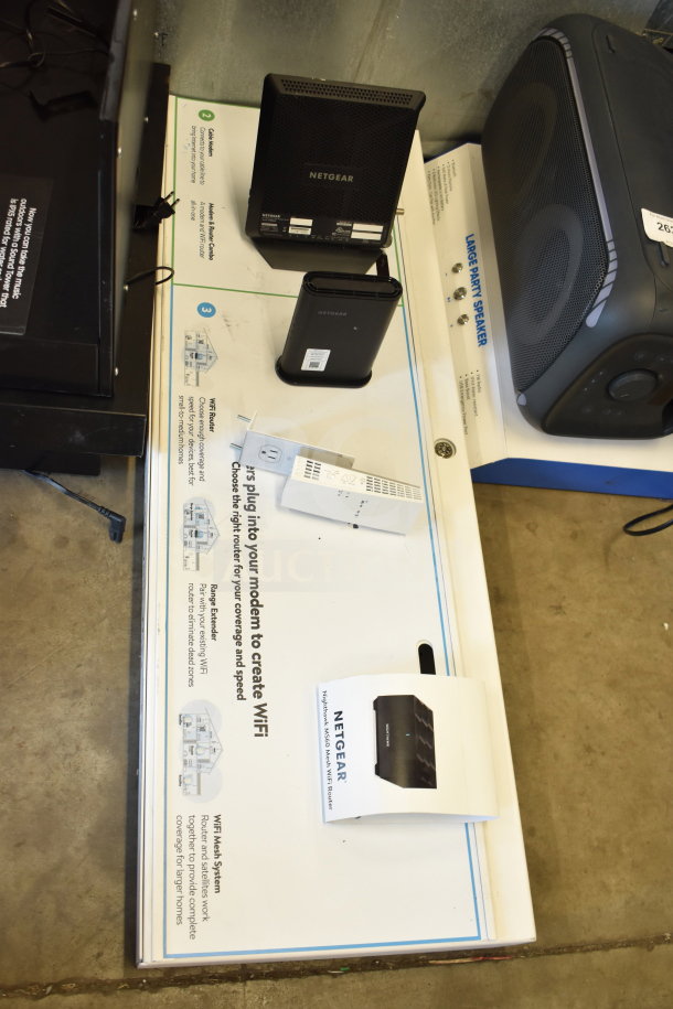 Netgear routers and accessories on a store display. Includes routers and extender, with packaging and product information.