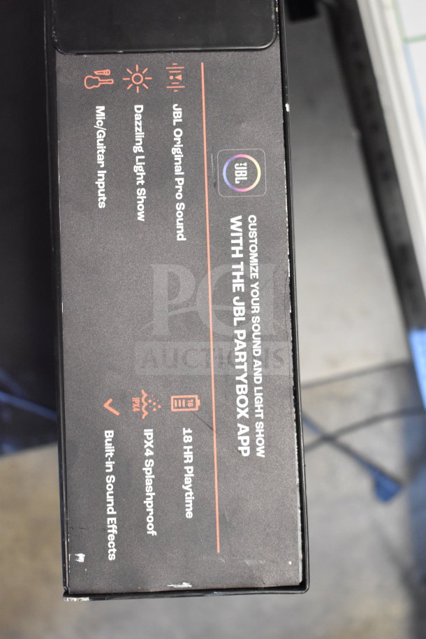 JBL PartyBox display box with features listed: Pro sound, light show, mic/guitar inputs, IPX4 splashproof, 18-hour playtime.