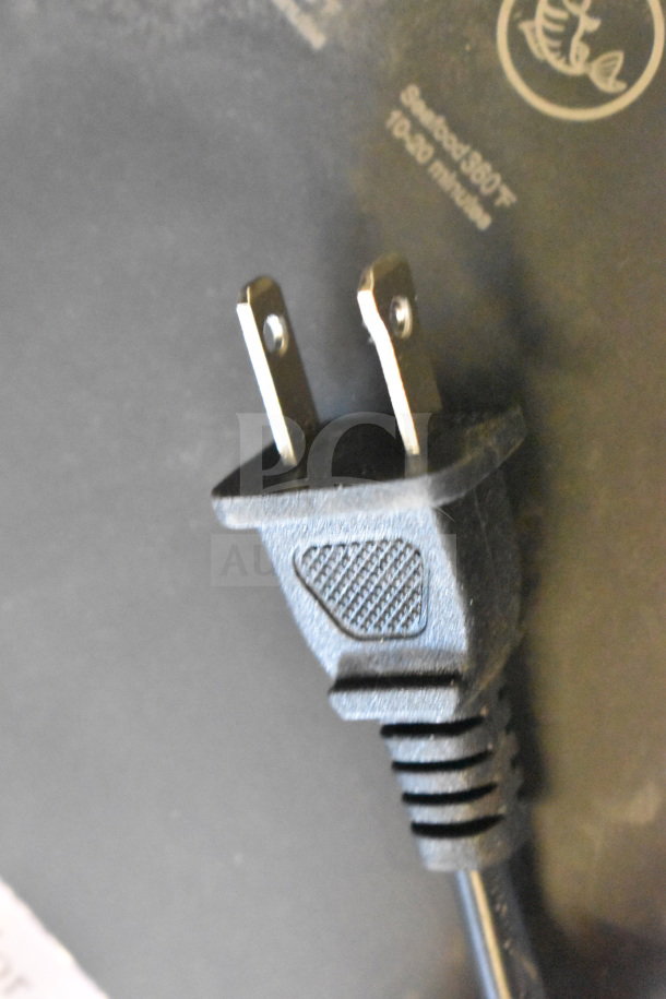 Power cord of Bluebow FD-1015B countertop air fryer. Electric plug detail, 110-120 V, with visible safety symbols.