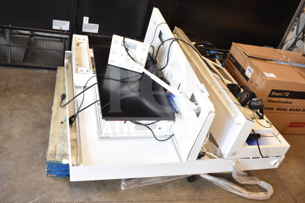 Store display with headphones and monitor, featuring multiple compartments, assorted cables, and visible cardboard boxes.