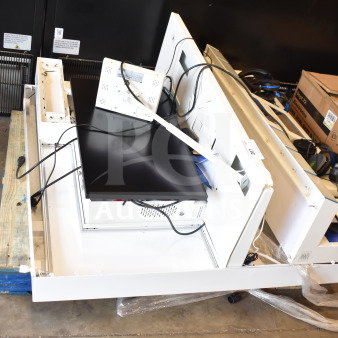 Store display with headphones and monitor, featuring multiple compartments, assorted cables, and visible cardboard boxes.
