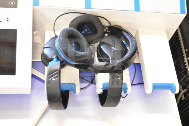 Store display featuring Turtle Beach headphones with black ear pads and blue accents on mounted holders.