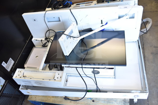 Store display with monitor and headphones, featuring a white frame. Cables are visible, unit appears used. Suitable for retail.